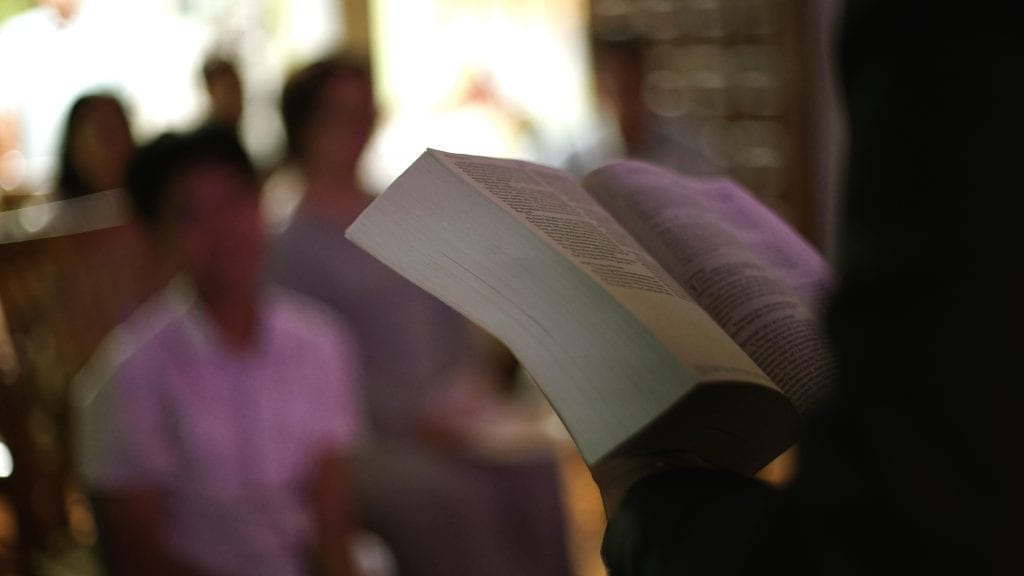 Bible being held while people are listening