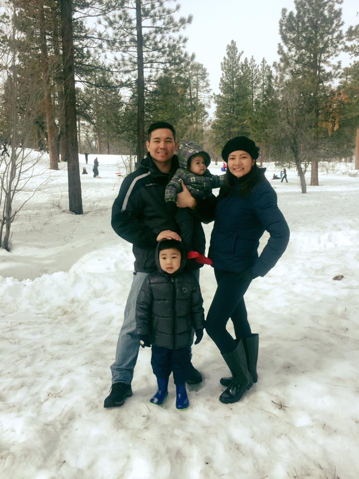 A family of 4 posing in the snow; 2 boys, mother, father.