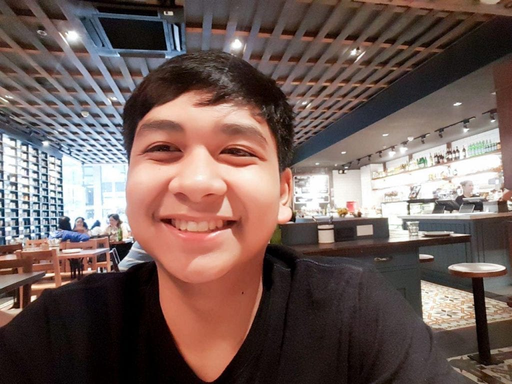A young man smiling in a restaurant.