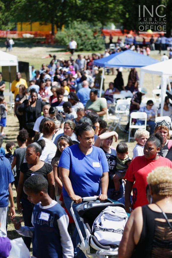Hundreds of Seattle residents wait patiently in line at Othello Playground to receive the free care packages being distributed by the FYM Foundation.