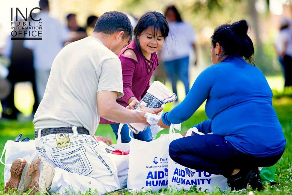 A family of care package recipients unpacks the household goods they’ve received from the FYM Foundation.