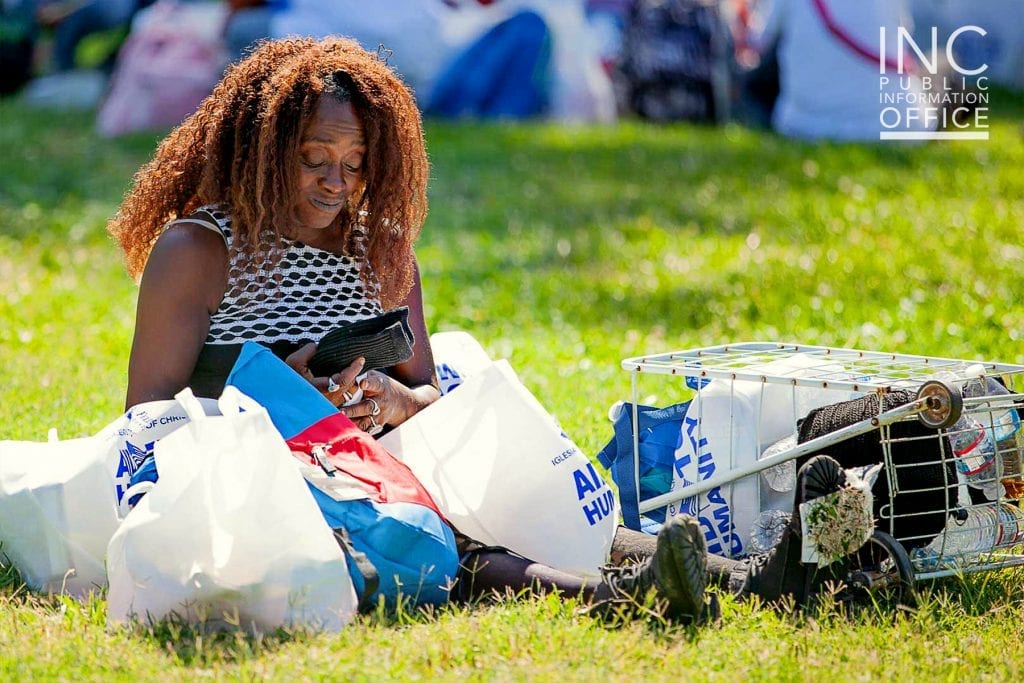 An Oakland resident unpacks the care packages she receives, examining the free new pair of socks she received.