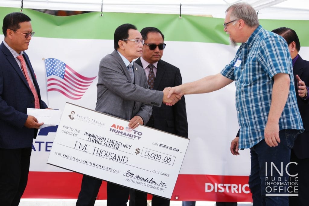 Don Rupp receiving the $5,000 donation from the FYM Foundation on behalf Downtown Emergency Service Center, shaking hands with Brother Glicerio B. Santos Jr., General Auditor of the Iglesia Ni Cristo and representative of the FYM Foundation.